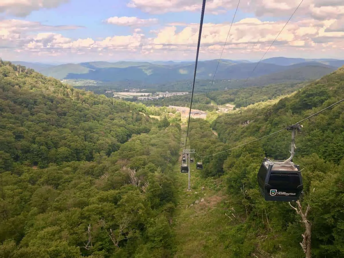 A Killington gondola cabin riding above forested slopes with valley and mountains beyond
